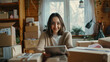 © VK Studio - A happy woman sits at a desk filled with shipping boxes, engaging with a tablet in her bright, plant-decorated workspace, emphasizing her passion and productivity.