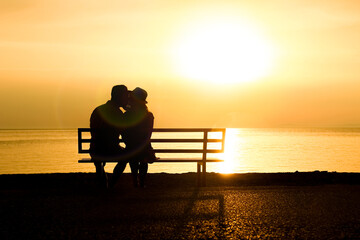 Wall Mural - A happy couple on a bench by the sea on nature in travel silhouette