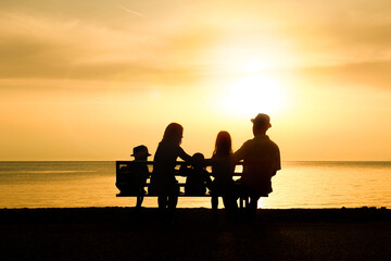 Poster - A happy family in nature by the sea on a trip silhouette