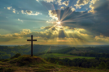 A cross on a hill overlooking a peaceful valley, with sunrays breaking through scattered clouds and illuminating the landscape below, creating a scene of tranquility and natural beauty