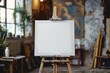 © itchaznong - A white canvas is propped up on a wooden easel. nobody in the room
