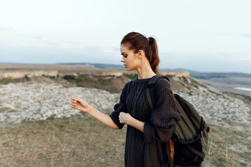 Wall Mural - adventurous woman standing on hilltop with backpack, enjoying scenic landscape view