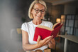© Miljan Živković - Portrait of mature senior woman stan and read a book at home