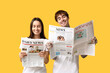 © Pixel-Shot - Young couple with newspapers on yellow background
