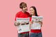 © Pixel-Shot - Young couple with newspapers on pink background