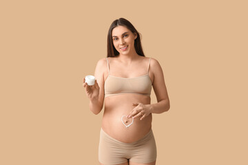 Sticker - Young pregnant woman with heart made of cream on her belly against beige background