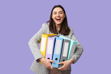 Wall Mural - Happy young businesswoman with folders on lilac background