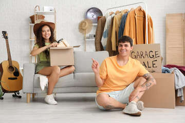 Poster - Young couple in room of unwanted stuff. Garage Sale