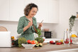 © Pixel-Shot - Mature woman stirring vegetable salad in kitchen