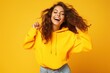 © Наталья некрасова - A happy, smiling young girl in a yellow sweater, posing on a yellow background. a positive brunette. Highlighted on a yellow background.