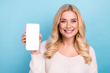 Canvas Print - Photo of charming pretty cheerful woman wear trendy clothes hold phone empty space isolated on blue color background