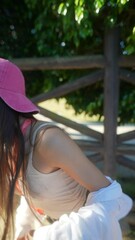 Canvas Print - A young girl wearing a cap is outdoors on a sunny day, enjoying nature and the bright sunlight