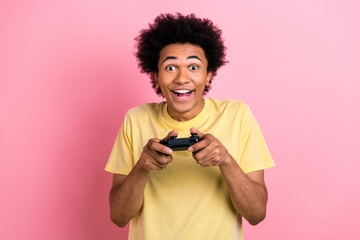 Poster - Photo of crazy overjoyed person hands hold controller enjoy playing video games isolated on pink color background