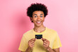 © deagreez - Photo of cheerful pretty guy dressed yellow t-shirt smiling holding credit card isolated pink color background
