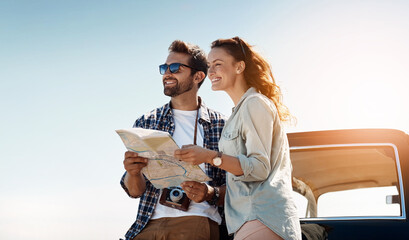 Canvas Print - Road trip, couple and map outdoor for destination, location search and navigation for travel. Happy people, man and woman with paper for guidance, direction and instructions for adventure journey