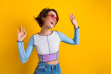 Wall Mural - Photo of shiny impressed woman wear top pink glasses having fun looking empty space isolated yellow color background
