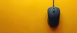 © Bolustck - Black gaming mouse on yellow background with copy space, top view. PC computer equipment for playing online games.