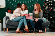 © HockleyMedia24/peopleimages.com - People, open presents and hug on Christmas for box, celebration and love for festive season. Women, friends and embrace for package on December holiday, bonding and tradition of giving on xmas party