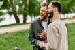 © Bliss - Two bearded men laugh together in a sunny green park.