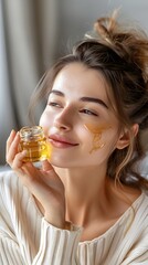 Beautiful smiling young woman with clean skin holding facial essential oil or serum with dropper, rejuvenation and skin care, white background