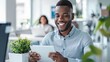 © LukaszDesign - Office, Indian man at desk with tablet and smile at computer, reading good news email or successful sales report online. Internet, social media, and business, grin, and communication.