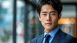 © Pixel Mind - A close-up portrait of a young man in a blue suit, looking directly at the camera with a serious expression