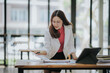 © Witoon - Attractive Asian businesswoman working at modern office with balance sheet documents. Accounting