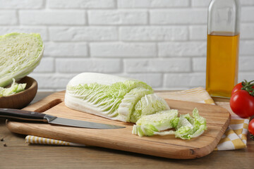 Cut fresh Chinese cabbage and knife on wooden table