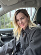 © Angelov - stylish and expressive blonde woman sitting in modern car and looking at camera, horizontal banner