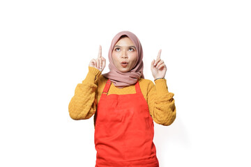 Wall Mural - Portrait of smiling woman in hijab and apron showing product with hand isolated on white background.