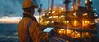 © Seksan - Close-Up of Engineer Using Tablet for Real-Time Data Analysis, Oil Rig Operations Scene
