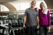 © ReadyAtTheEase/peopleimages.com - Mature couple, fitness and portrait at gym, smile and dumbbell for training, bottle and exercise together. Man, woman and happy with bonding, workout and connection with water at wellness club