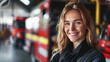 © standret - Portrait of a happy female firefighter standing in a fire station