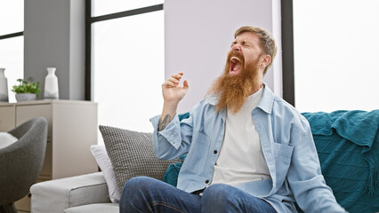 Poster - Troubled young redhead man, alone indoors, stress screaming on the sofa