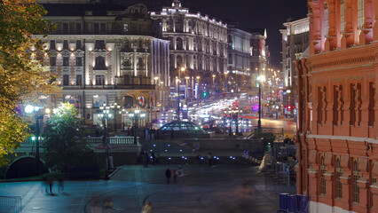 Wall Mural - People walking on Manezh Square at night in Moscow. Tverskaya Street is in the background timelapse