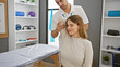 © Krakenimages.com - A female patient receives shoulder therapy from a male physiotherapist in a well-equipped rehab room.