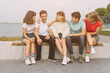 © anatoliycherkas - Summer holidays and teenage concept - group of smiling teenagers hanging out outside.