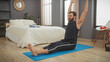 © Krakenimages.com - Bearded man stretching on a yoga mat in a modern bedroom setup demonstrating a healthy lifestyle and indoor fitness routine.