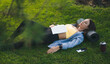 © Strelciuc - Young woman asleep in the park, holding a book on her chest. Tired after workout.
