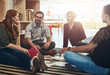 © peopleimages.com - Group, circle or business people sitting on floor for collaboration, documents and notes for ideas. Teamwork, huddle or meeting with manager for company plan, discussion for strategy in office