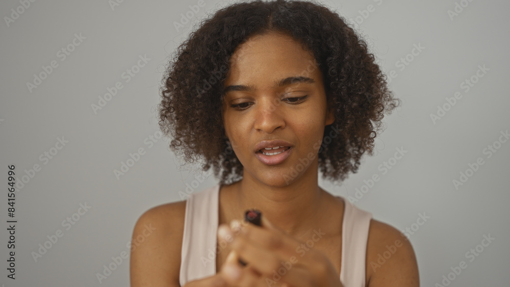 Young african american woman with curly hair posing over an isolated ...