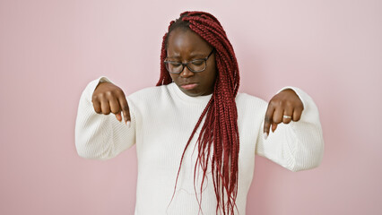 Wall Mural - African american woman with braids expressing sadness over a pink isolated background wall.