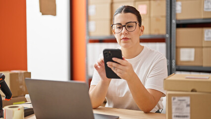 Canvas Print - Young beautiful hispanic woman ecommerce business worker using smartphone at the office