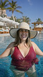 © Krakenimages.com - A smiling young woman in a swimsuit and sunhat relaxes in a luxury pool with tropical palms in the background.