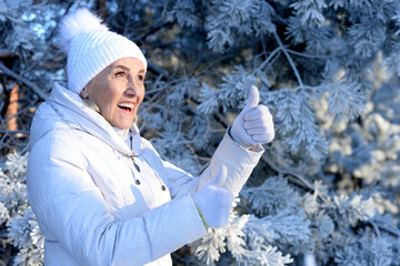 Beautiful elderly woman posing in a snowy winter park