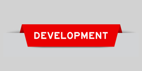 Red color inserted label with word development on gray background