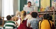 © peopleimages.com - Kindergarten, children and teacher reading a story in montessori school, classroom and learning. Kids, fairytale and woman teaching language with creative fantasy stories in preschool education