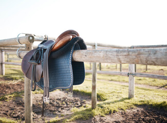 Canvas Print - Saddle, countryside and farm on ranch fence, riding and equestrian sports in nature or park. Background, agriculture or field in Texas, USA with leather seat or equipment for outdoor hobby in paddock