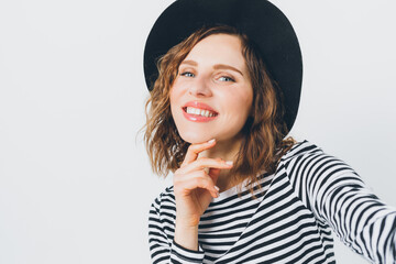 Wall Mural - A woman with a black hat and a white and black striped shirt is smiling