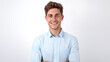 © GraphicXpert11 - A smiling millennial man with folded arms, dressed in a light blue shirt, posing isolated on a white solid-colored background, looking confidently at the camera.